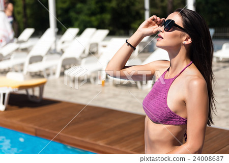 Delighted beautiful woman resting near swimming Delighted beautiful woman resting near swimming 24008687