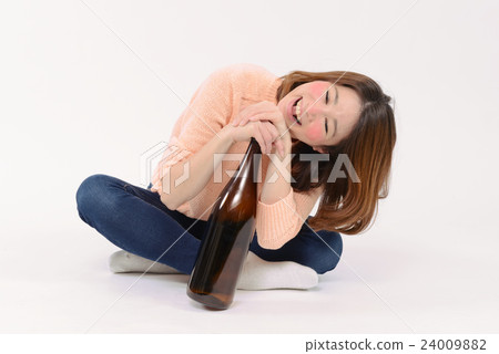A drunken young lady holding one bottle A drunken young lady holding one bottle 24009882