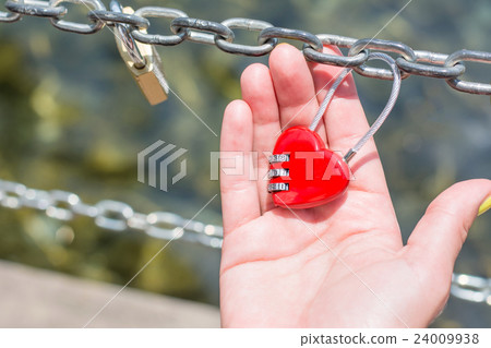 Woman hand holding heart shaped padlock 24009938