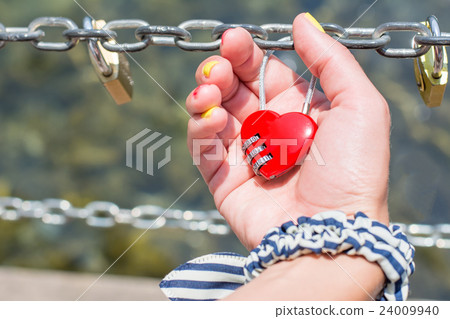 Woman hand holding heart shaped padlock Woman hand holding heart shaped padlock 24009940