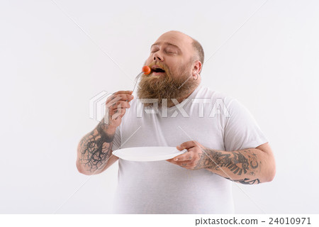 Hungry thick guy eating tiny vegetable Hungry thick guy eating tiny vegetable 24010971