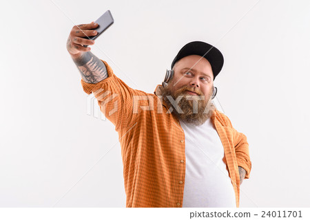 Male fatso listening to music while photographing 24011701