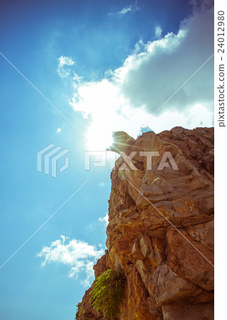 Steep rocks with place against sun sky backlight 24012980