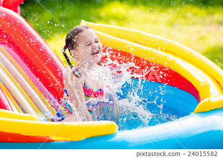 Little girl in garden swimming pool Little girl in garden swimming pool 24015582