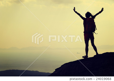 young asian woman open arms on mountain peak cliff young asian woman open arms on mountain peak cliff 24019068
