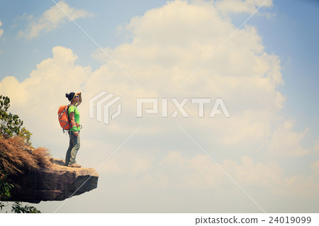 woman hiker enjoy the view on mountain top cliff 24019099
