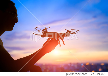 silhouette of man take drone 24019368