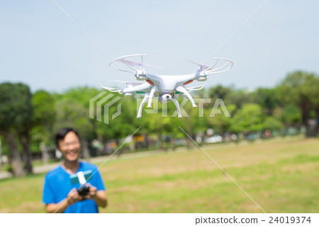 man play drone in park 24019374