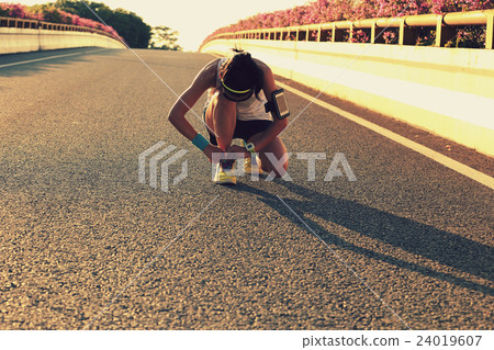 young fitness woman runner tying shoelace on road young fitness woman runner tying shoelace on road 24019607