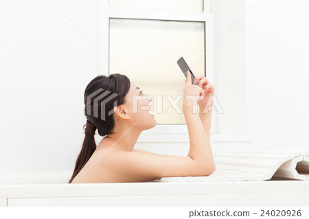 A woman who likes a smartphone in a bath 24020926
