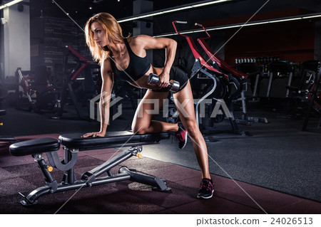 Girl pumping up muscles with dumbbells 24026513
