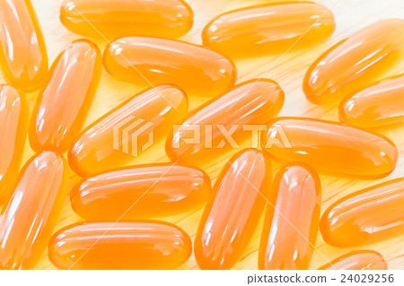 Close up gel capsule on wooden table 24029256