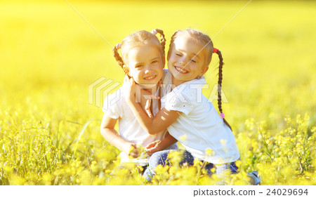 happy children twins sisters embracing in summer on nature 24029694