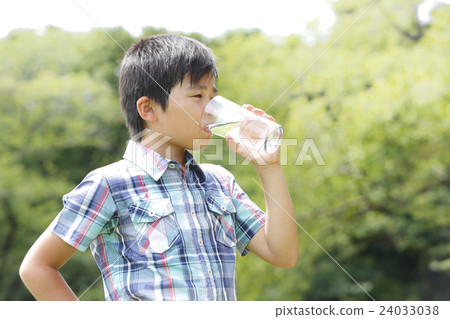 A boy drinking water in a cup A boy drinking water in a cup 24033038