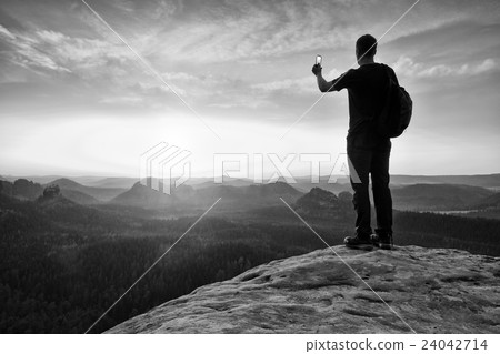 Tall backpacker with phone in hand. 24042714