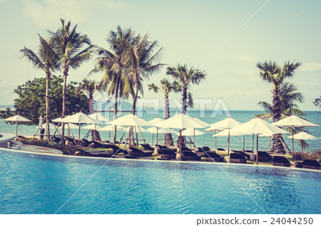 Umbrella and chair around swimming pool Umbrella and chair around swimming pool 24044250