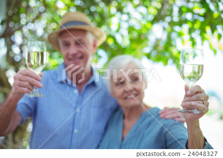 Couple holding white wine  24048327
