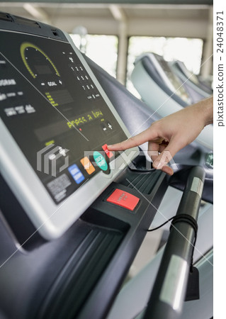 Woman touching the console display of treadmill Woman touching the console display of treadmill 24048371