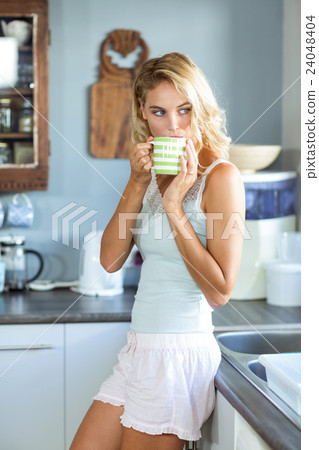Beautiful woman having coffee in kitchen 24048404