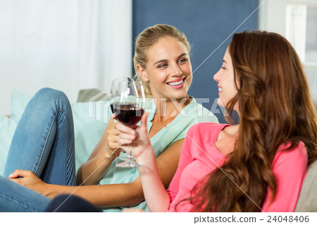 Happy female friends toasting wine Happy female friends toasting wine 24048406