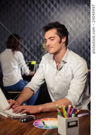 Creative businessman working on computer Creative businessman working on computer 24048497