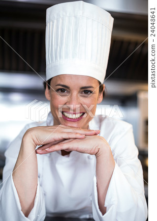 Portrait of happy female chef with hands on chin Portrait of happy female chef with hands on chin 24048641