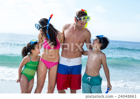 Happy family with diving goggles at beach  24048661