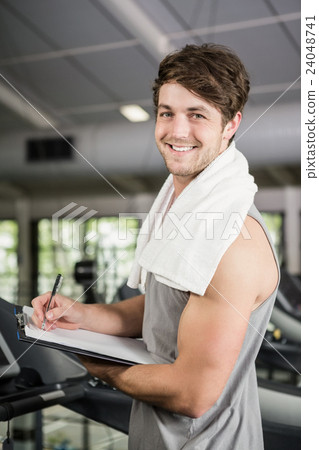 Gym instructor writing on clipboard Gym instructor writing on clipboard 24048741