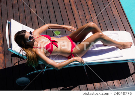 Woman enjoying sunbath on the pool edge Woman enjoying sunbath on the pool edge 24048776