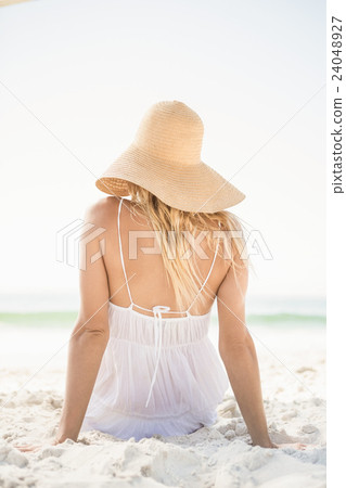 Blonde woman sitting on sand Blonde woman sitting on sand 24048927