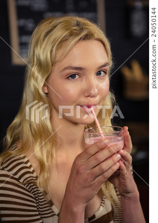 Woman drinking a milkshake Woman drinking a milkshake 24050144
