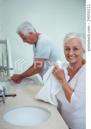 Senior woman and man cleaning hands in bathroom Senior woman and man cleaning hands in bathroom 24050211