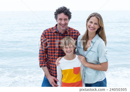 Happy parents standing with son by sea Happy parents standing with son by sea 24050305