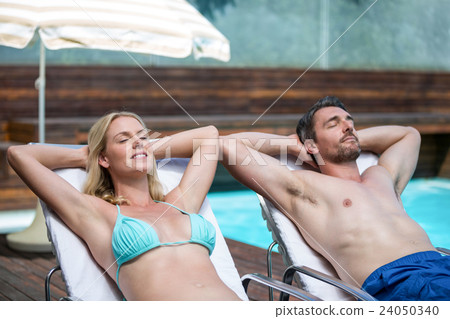 Couple relaxing on a sun lounger 24050340