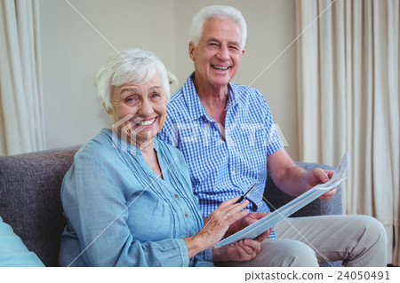 Smiling senior couple with bills  24050491