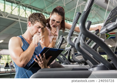 Trainer and a woman looking at the clipboard Trainer and a woman looking at the clipboard 24050728