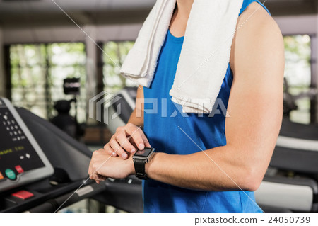 Man using smart watch on treadmill Man using smart watch on treadmill 24050739