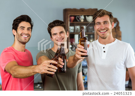 Portrait of male friends toasting beer bottles Portrait of male friends toasting beer bottles 24051323