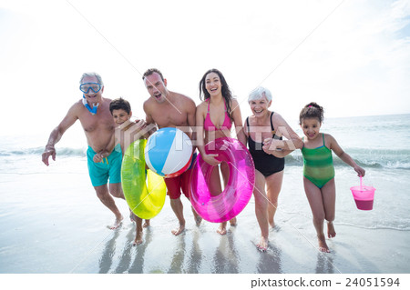 Happy multi-generation family running at beach Happy multi-generation family running at beach 24051594
