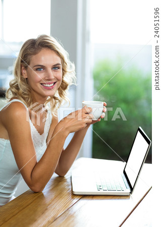 Portrait of happy woman holding coffee cup Portrait of happy woman holding coffee cup 24051596