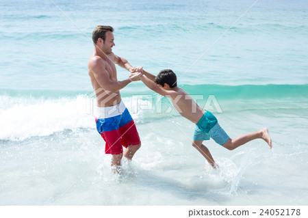 Father playing with son at beach Father playing with son at beach 24052178