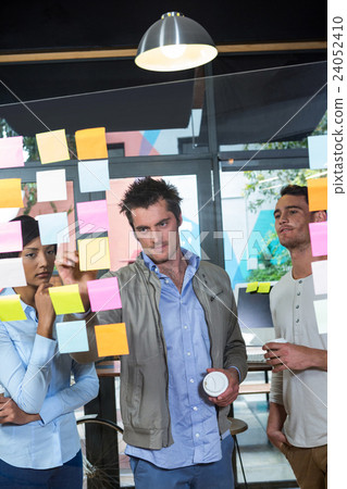 Colleagues looking at sticky notes 24052410