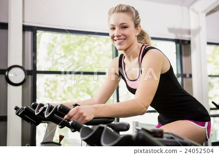 Woman sitting on exercise bike 24052504