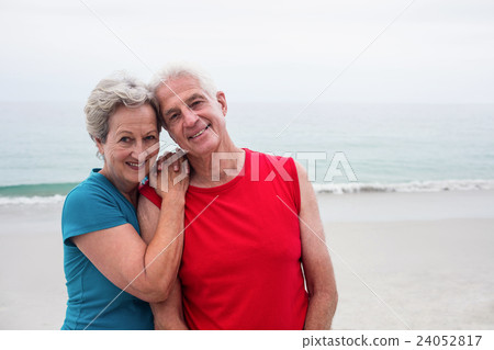 Happy senior couple embracing each other on the beach 24052817