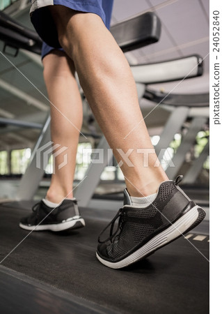 Man's feet while walking on thread mill Man's feet while walking on thread mill 24052840