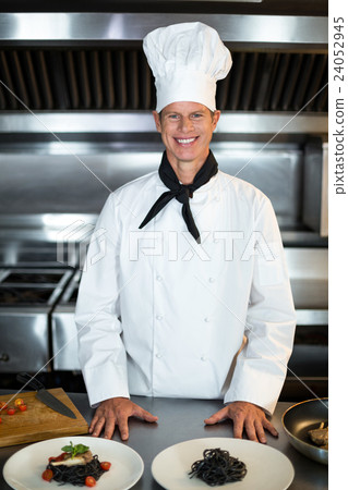 Portrait of smiling chef in kitchen Portrait of smiling chef in kitchen 24052945