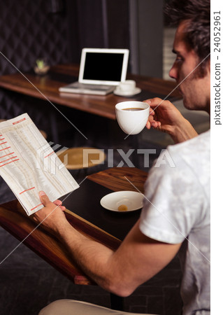 Hipster man reading while drinking coffee 24052961