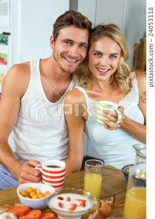 Loving couple having coffee at breakfast table in house Loving couple having coffee at breakfast table in house 24053118