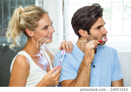 Couple brushing their teeth in bathroom Couple brushing their teeth in bathroom 24053203
