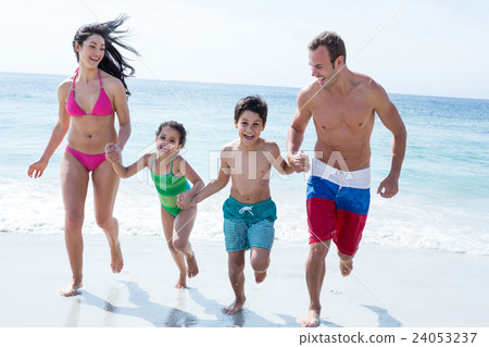 Family running while holding hands at beach Family running while holding hands at beach 24053237